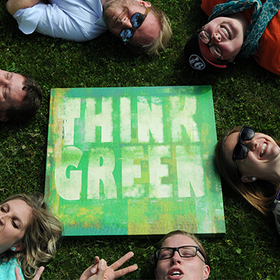 Think green poster in center of employees round shot from top.