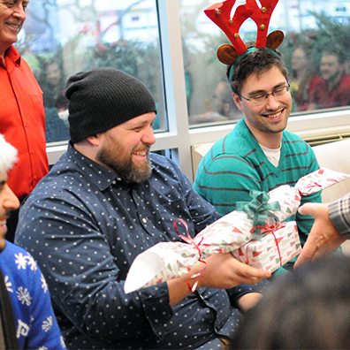 Christmas celebration: Employees smiling and exchanging gifts.