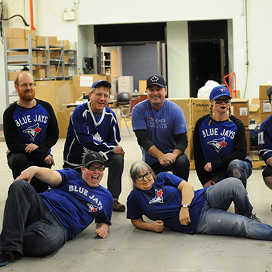 Group of employee posing with Jays game tshirts.